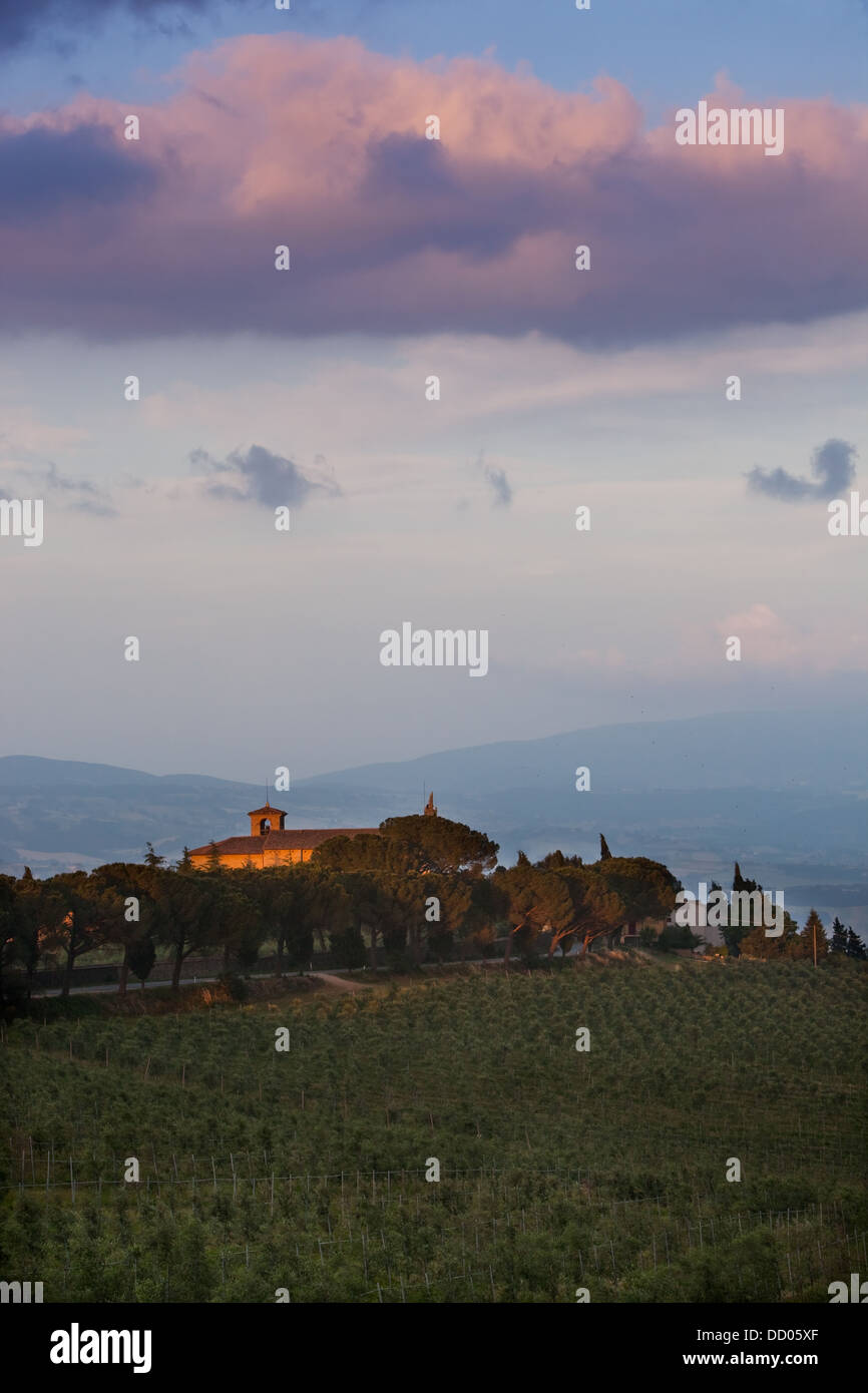 Italian rural abbey at sunset, with spectacular cloud formation, vineyards on sloping hills of foreground Stock Photo