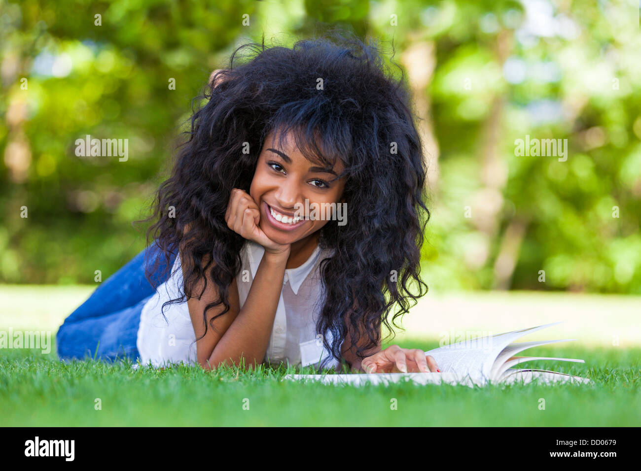Young student girl reading a book in the school park - African people Stock Photo