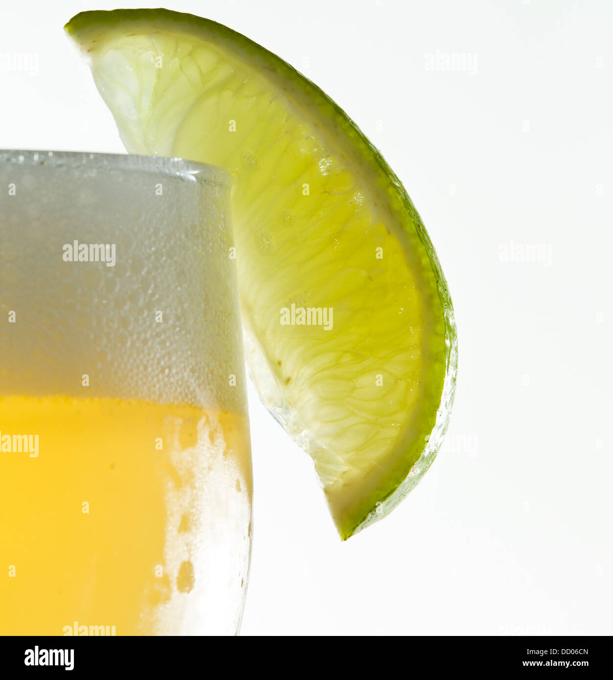 Beer Rim cold beer served with a lime wedge on the rim, isolated on a white ...