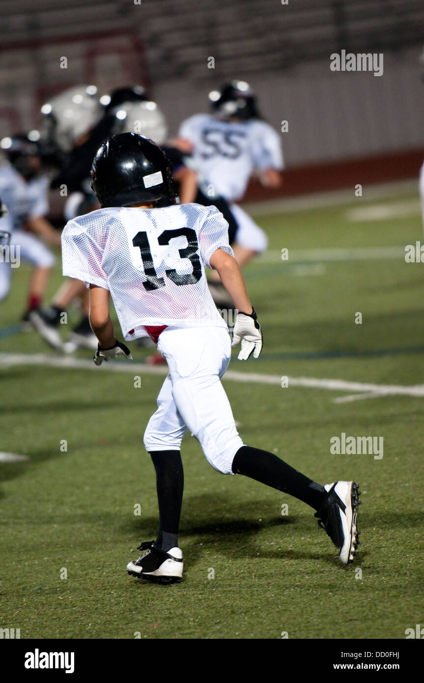 Youth american football boy playing defense watching the ball. Stock Photo