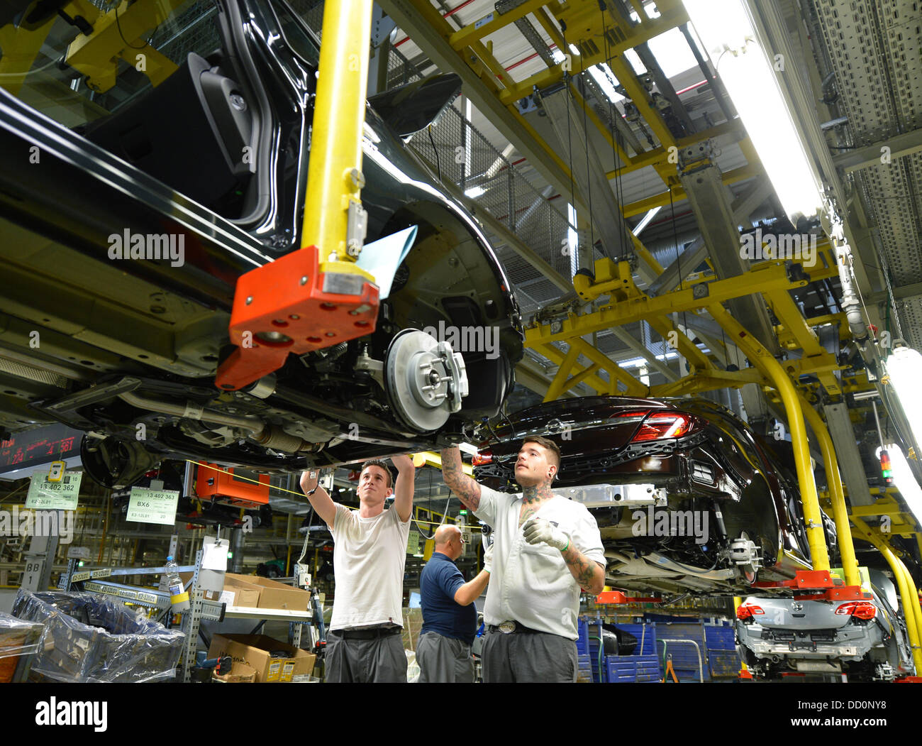 Opel employees screw parts on different car models in the production in ...