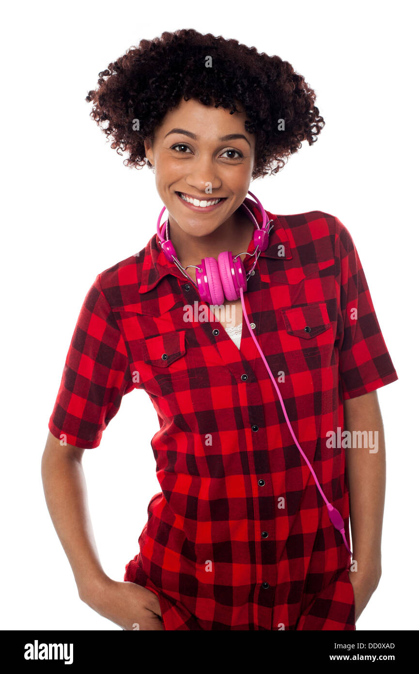 Fashionable female posing with headphones around her neck isolated over