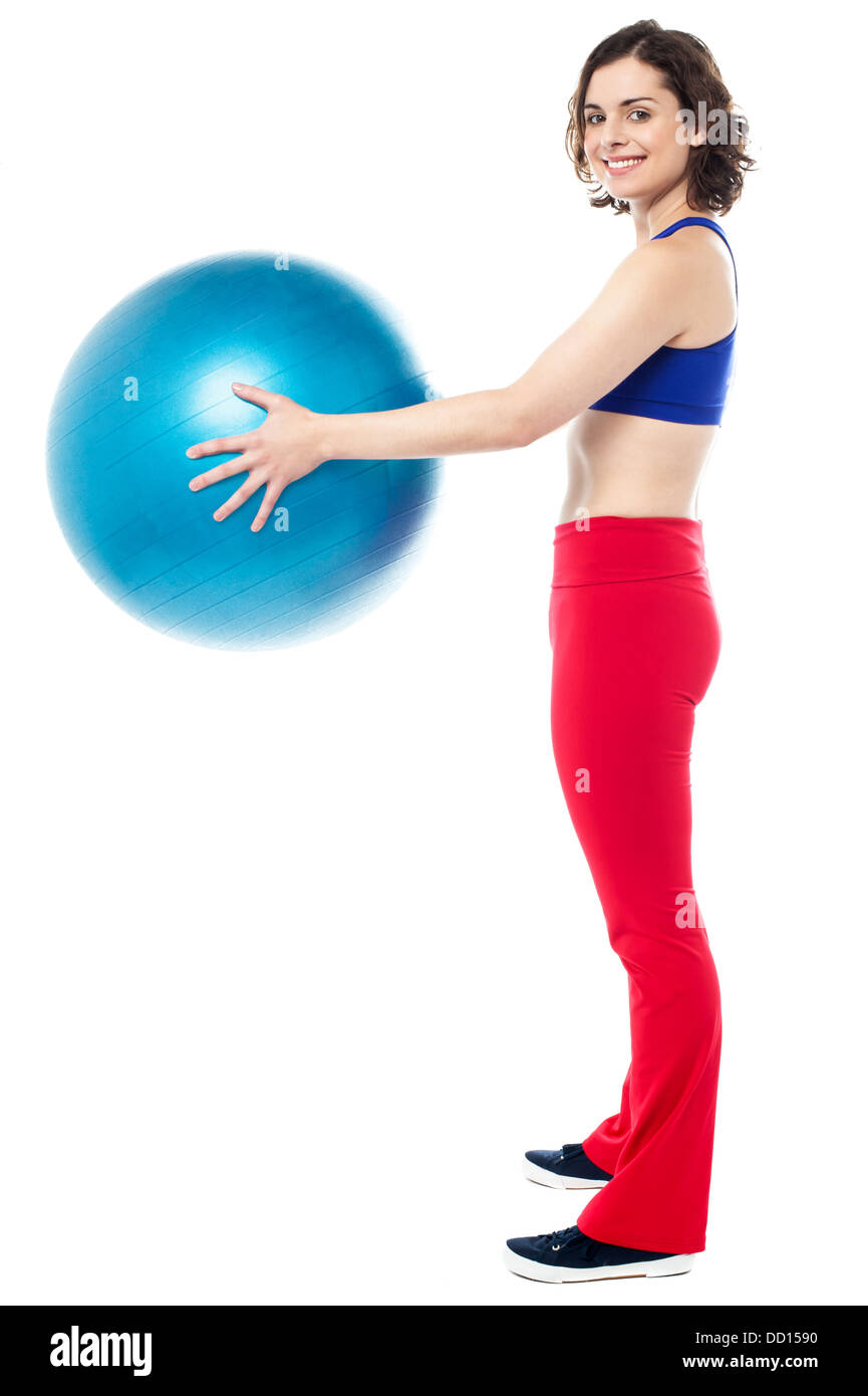 Side profile of a fit woman holding an exercise ball in her outstretched arms. Stock Photo