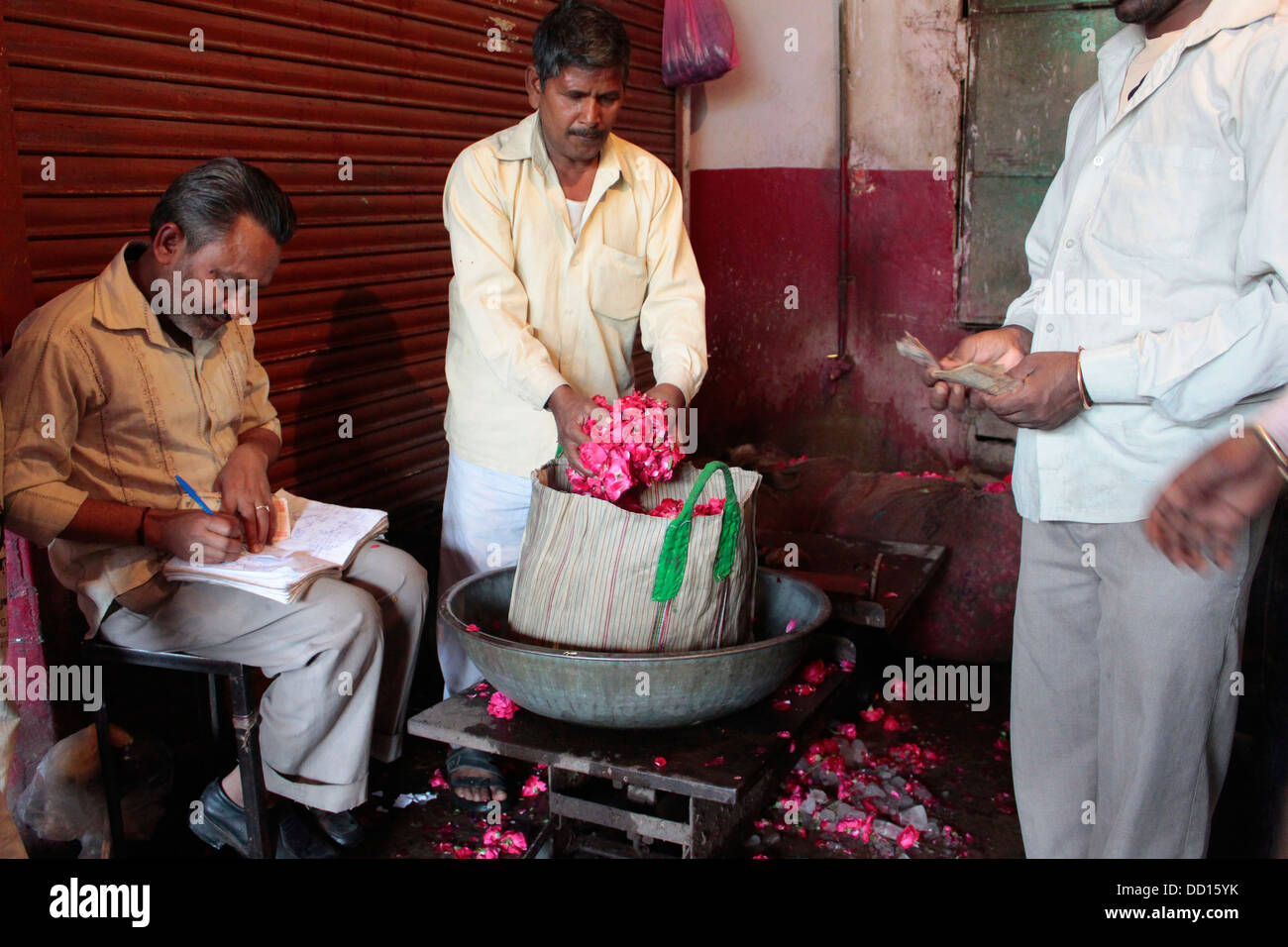 A seller weighs flowers at the Chandni Chowk flower market in Old Delhi