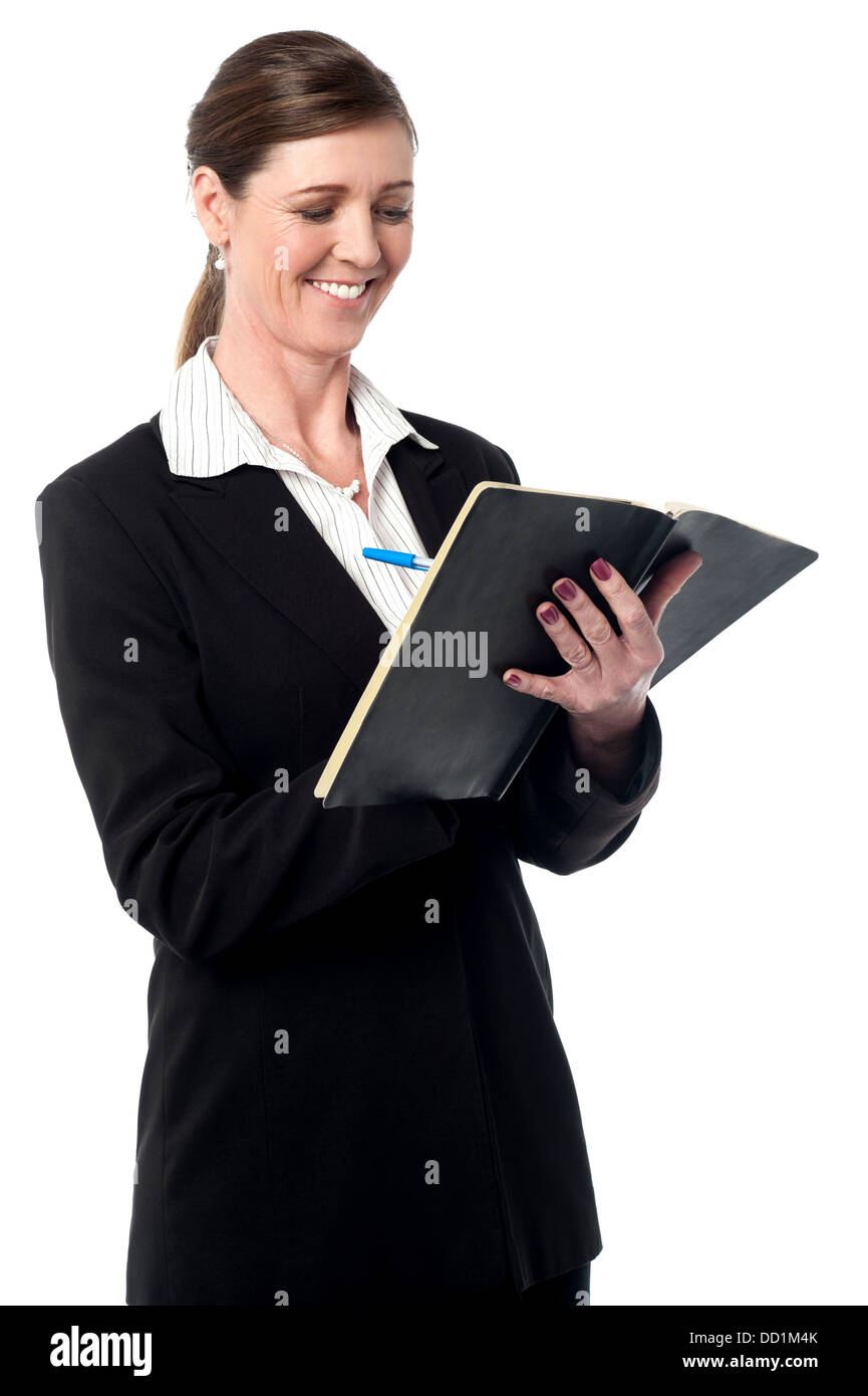 Business lady marking her schedule in her daily planner diary stock