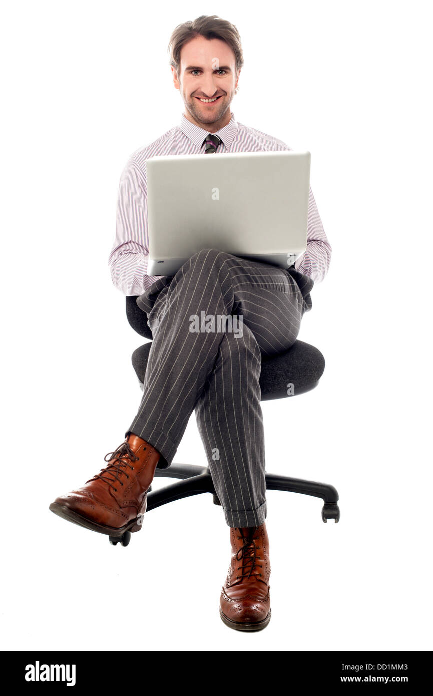 Businessman sitting on the chair with laptop Stock Photo - Alamy