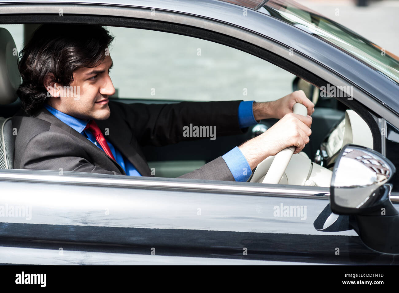 Handsome young businessman driving his new car Stock Photo - Alamy