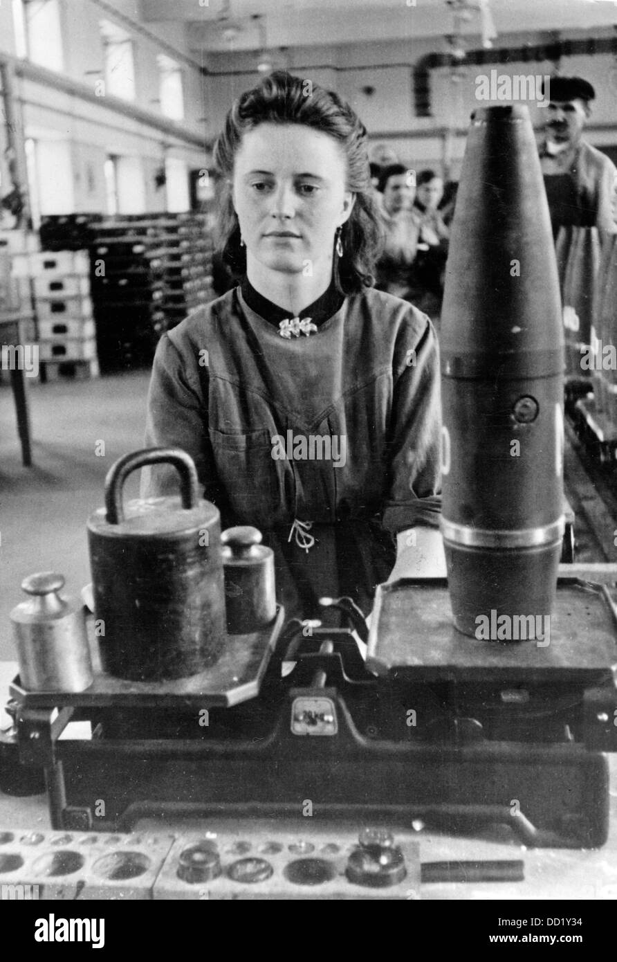 The image from the Nazi Propaganda! shows a young woman weighing grenades in an ammunitions factory in March 1941. Place unknown. The employment of women as workers in all sectors was supposed to compensate for the lack of workers because of the deployment of the men. Fotoarchiv für Zeitgeschichte Stock Photo