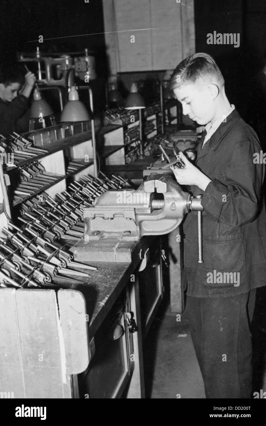 Members of the Hitler Youth produce toys for the children of soldiers in the context of the war service of the Hitler Youth in the workshop of Siemens & Halske AG in November 1942. The Nazi Propaganda! on the back of the image is dated 21 November 1942: 'Armament race of the Hitler Youth is part of the war service of the Hitler Youth, in which the youth organization with millions of members including the ones of the Country Service, Eastern Service and Kinderlandverschickung (KLV - Evacuation of Children Service) produce toys for the children of soldiers and closes gaps, which were created by  Stock Photo