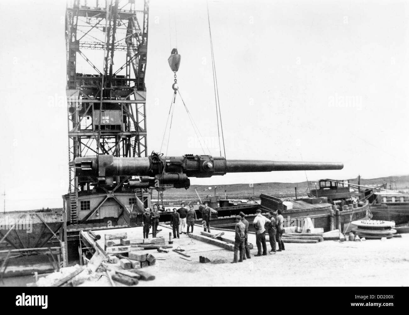 Delivery of a gun for the military operations at the Atlantic Coast in July 1942, place unknown. Under the name of 'Organisation Todt' fortified defense systems and bunkers were constructed along the Atlantic Coast for the defense against the Allies. The Nazi Propaganda! on the back of the picture is dated 13 July 1942: 'Heavy artillery for the war against England. Strenuously, the works to extend the fortifications along the coast and consolidate the net of bunkers and artillery bases are pursued. Here the massive guns for defending against attacks of hostile naval forces are lifted onshore b Stock Photo