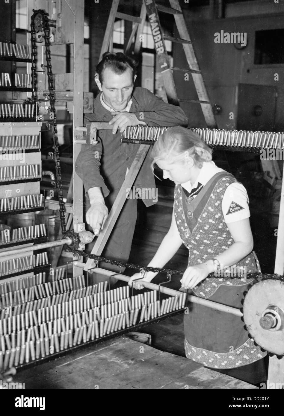 The image from the Nazi Propaganda! shows a member of the Bund Deutscher Mädel (BDM - The League of German Girls) as she receives instructions for her new task in an ammunitions factory, place unknown. The employment of women as workers in all sectors was supposed to compensate for the lack of workers because of the deployment of the men. Fotoarchiv für Zeitgeschichte Stock Photo