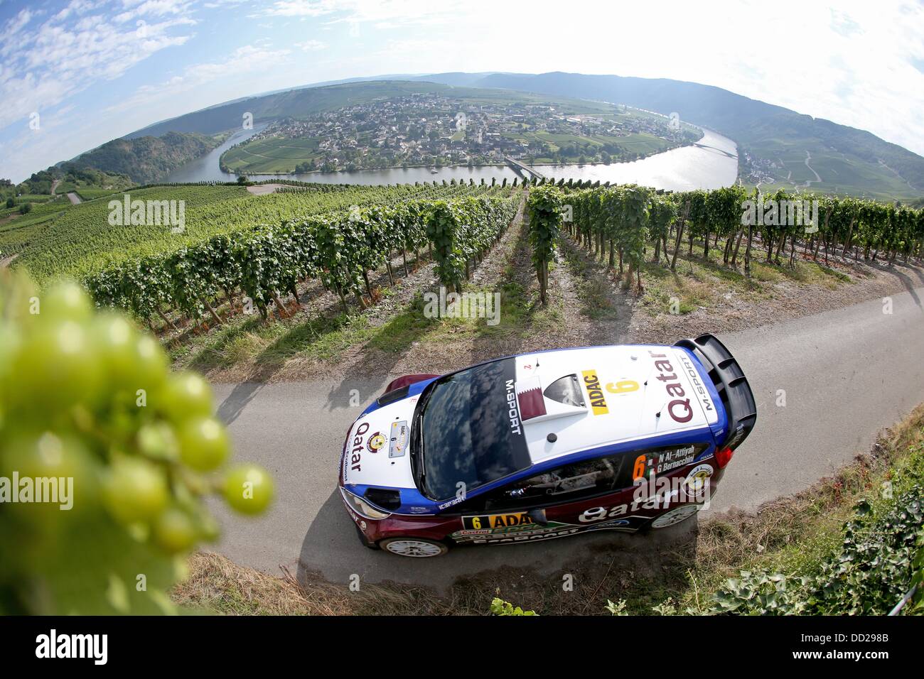 Piesport, Germany. 23rd Aug, 2013. Qatar-born rallye pilot Nasser Al-Attiya and his Italian co-pilot Giovanni Bernacchini drive through the vineyards during the fourth competition of the ADAC Rallye Deutschland, which is part of the FIA World Rally Championship, near Piesport, Germany, 23 August 2013. Photo: THOMAS FREY/dpa/Alamy Live News Stock Photo