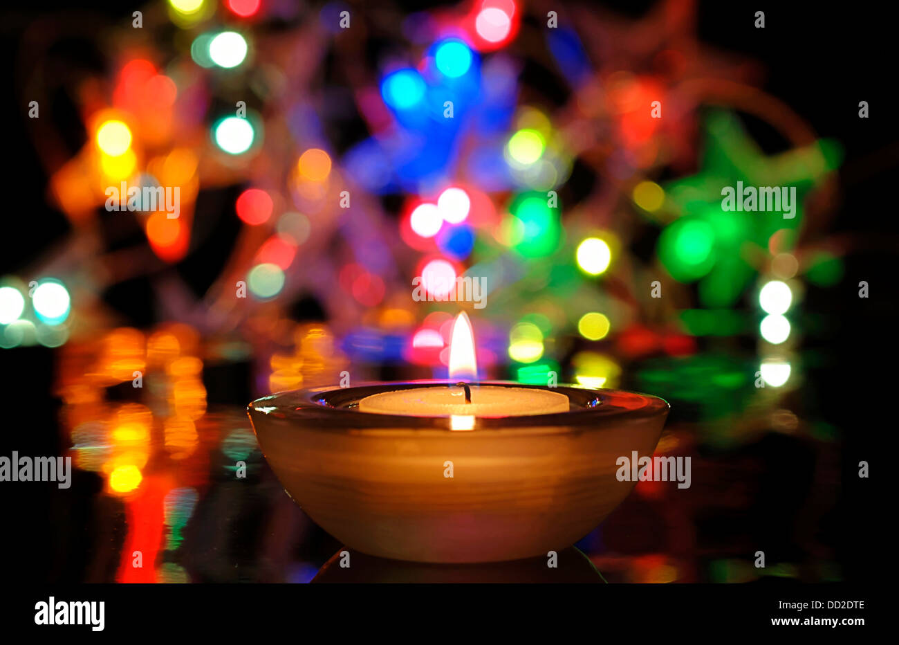 Christmas lights and burning candle Stock Photo