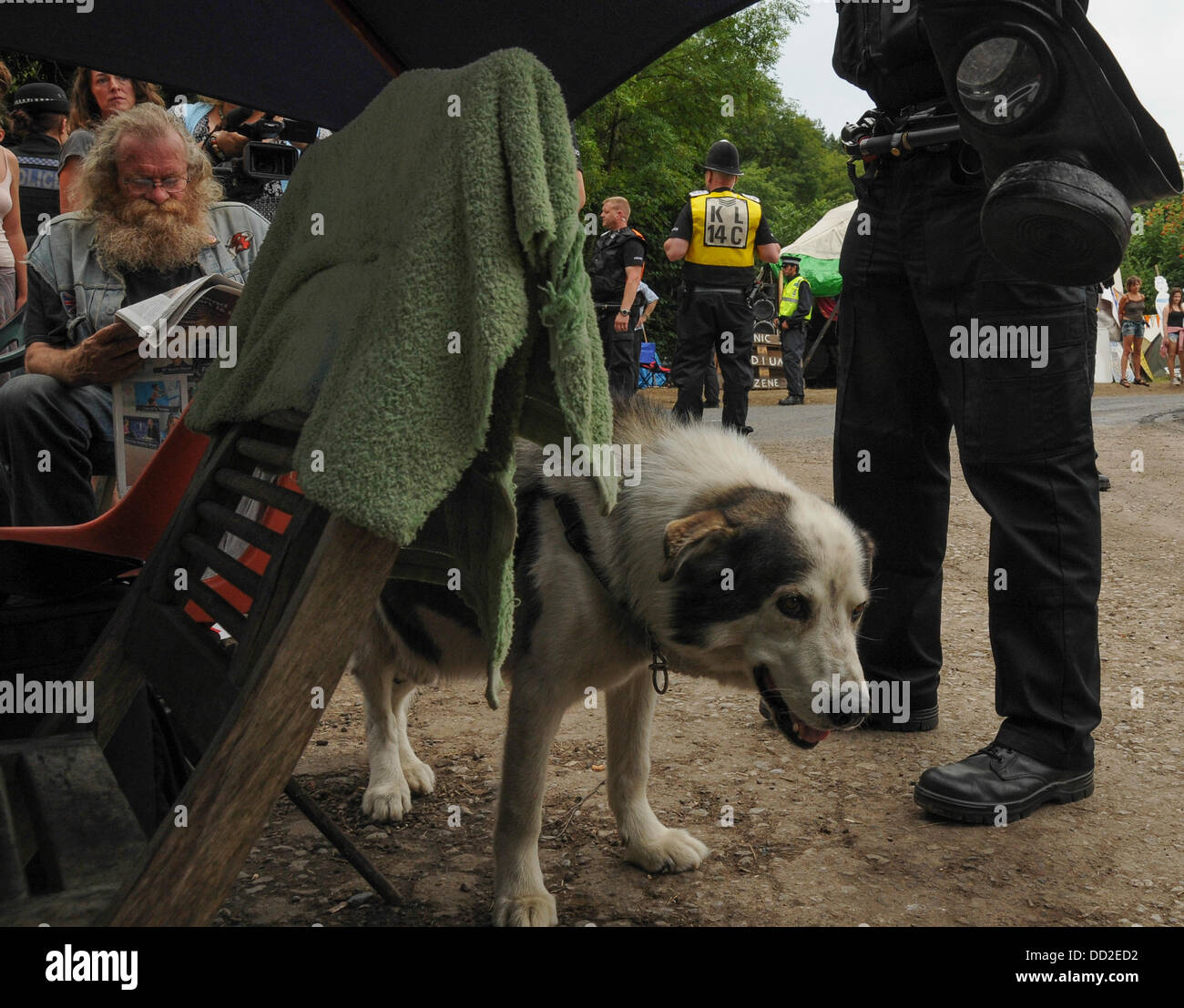 Balcombe, Sussex, UK. 23rd Aug, 2013. Canine environmentalist at Balcombe, owner reads the paper after another lorry leaves the site. Credit:  David Burr/Alamy Live News Stock Photo