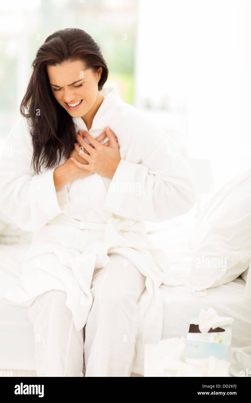 young woman in pajamas having heart attack Stock Photo