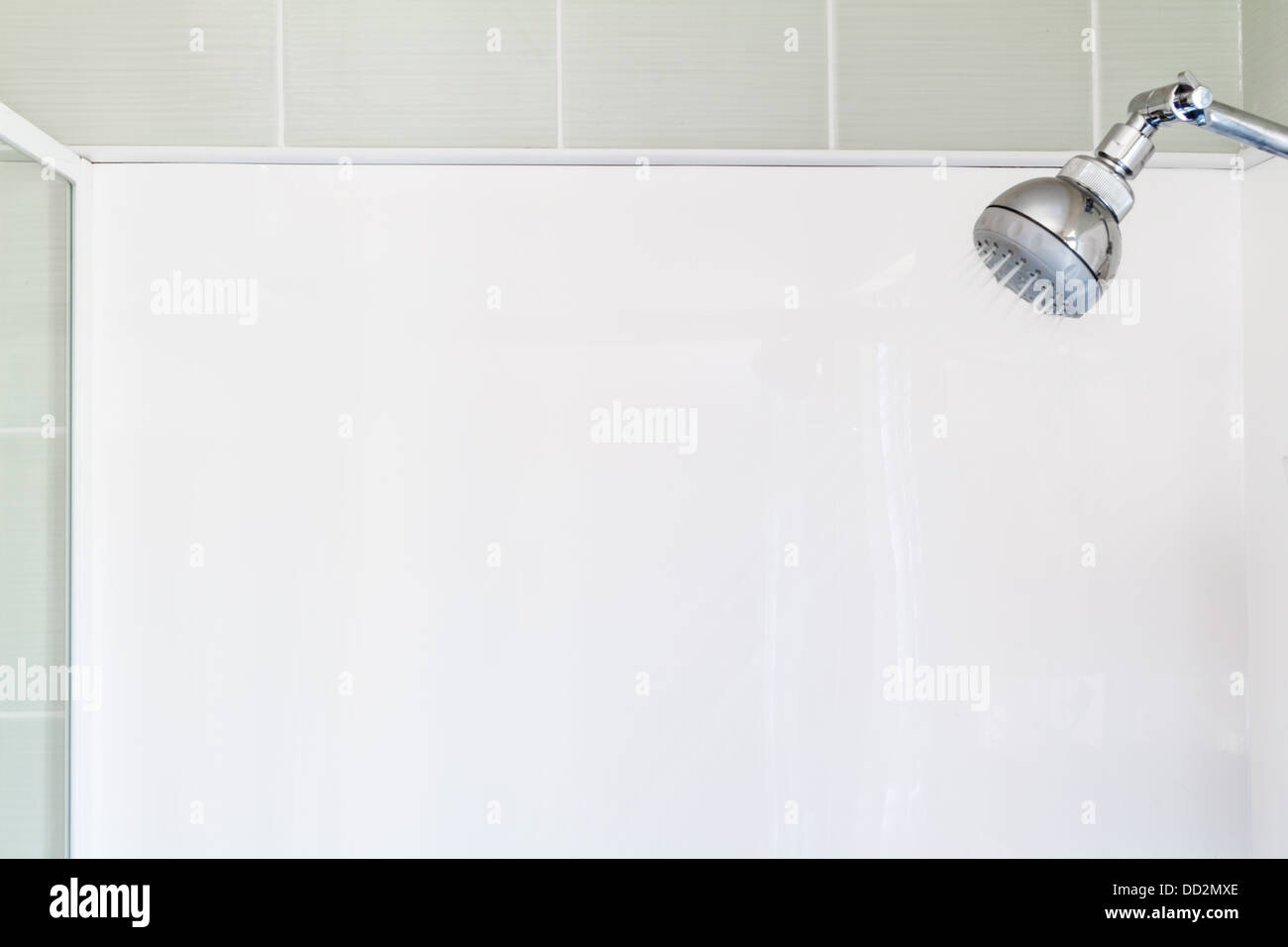A running shower with a blank white walls and green tiles. Plenty of space for your own message Stock Photo