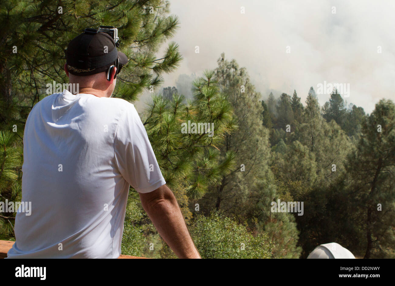 Buck Meadows, CA, USA. 23rd Aug, 2013. Ken Canobbio watches from his deck as smoke and flames get closer to his Pine Mountain Lake, CA home home on Cliffton Way. The Rim Fire in the Stanislaus National Forest along Highway 120 continues to grow. According to the US Forest Service as of Friday Aug. 23rd 2013 afternoon the fire has grown to 125,620 acres with only 5% containment with more evacuations in Tuolumne City, CA and nearby areas along the Highway 108 corridor. The fire continues to spread in several directions including towards Yosemite National Park. (Credit Image: © Marty Bicek/ZUM Stock Photo