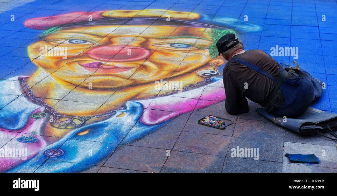 Street artist is drawing a clown on the streets of berlin Stock Photo