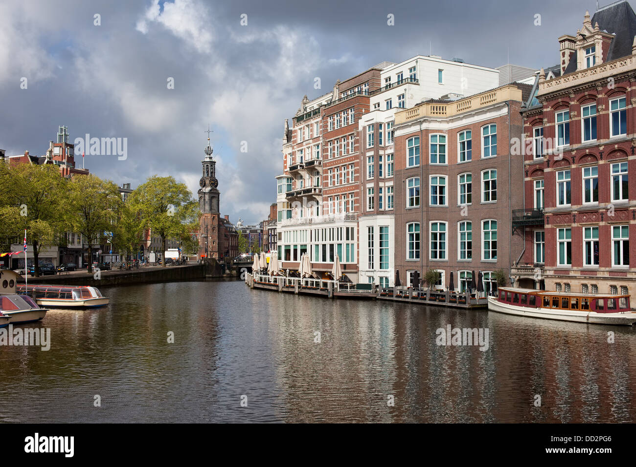 City of Amsterdam by the river Amstel in Netherlands, Mint Tower (Munttoren) at the far end. Stock Photo