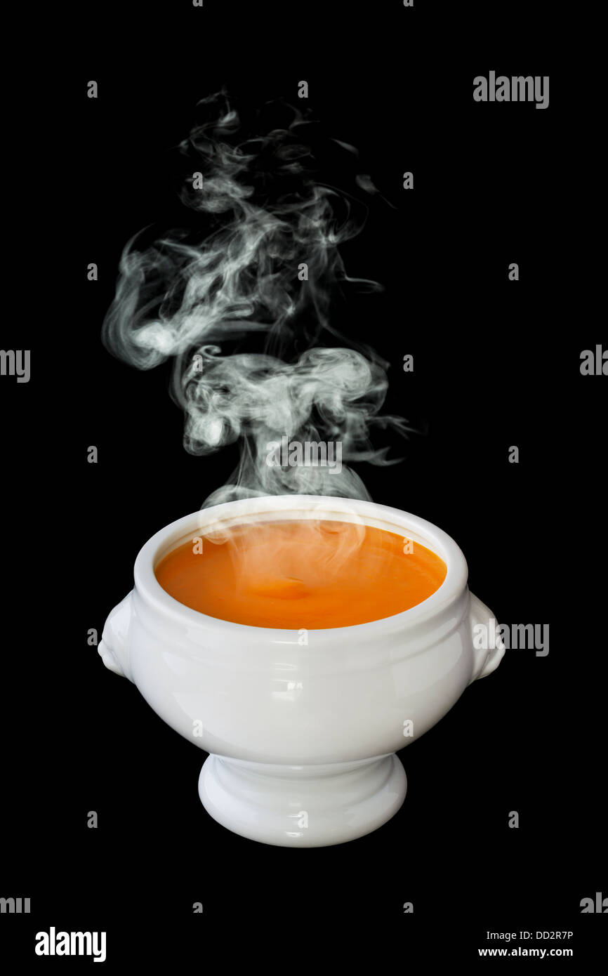 Tomato Soup - a bowl of steaming hot tomato soup, in a lion head bowl, on a black background, front to back focus Stock Photo