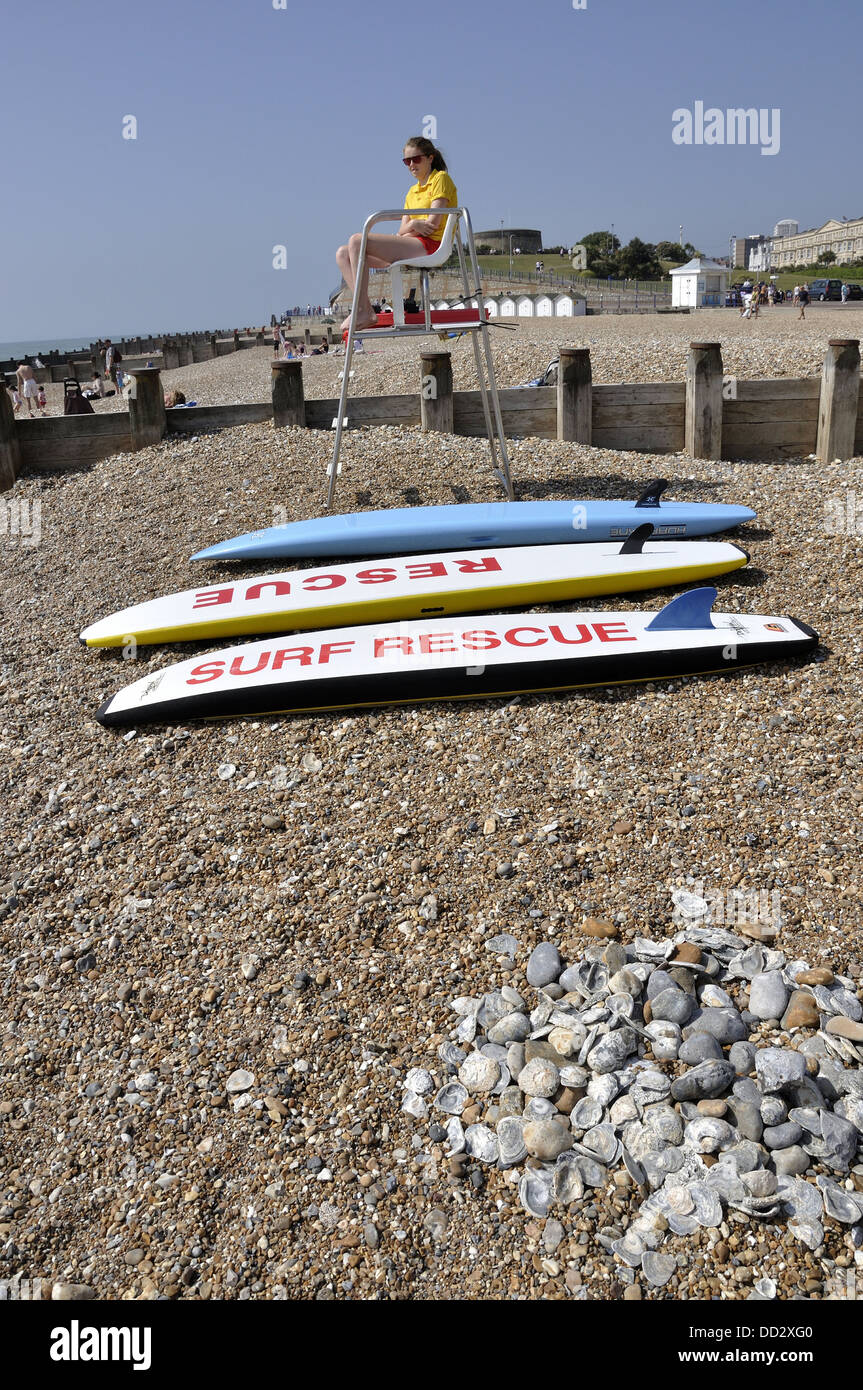 Female lifeguard on Eastbourne beach with three rescue boards in