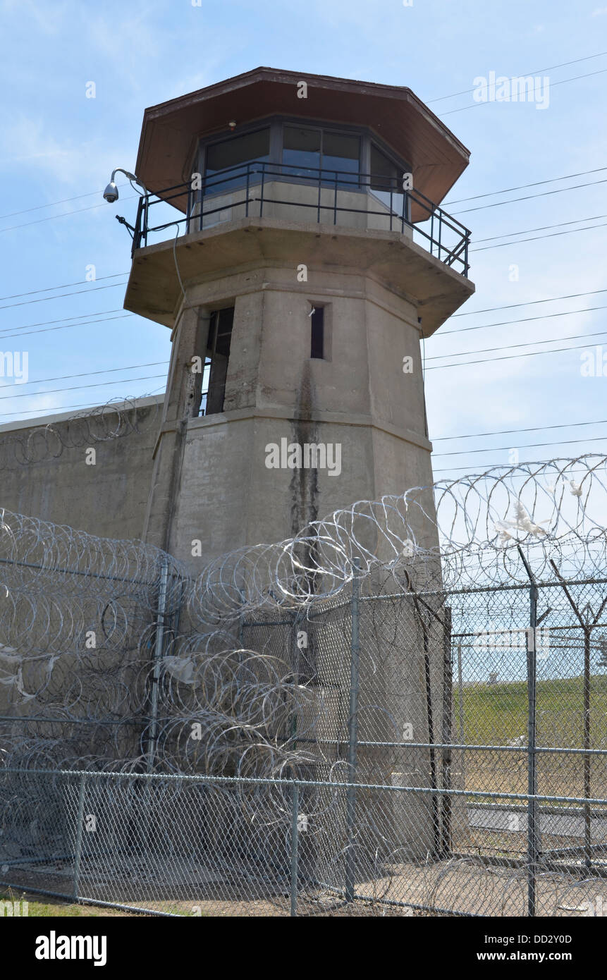 American maximum security prison guard tower and perimeter wall. Tower officers are armed with rifles and shotguns. Stock Photo
