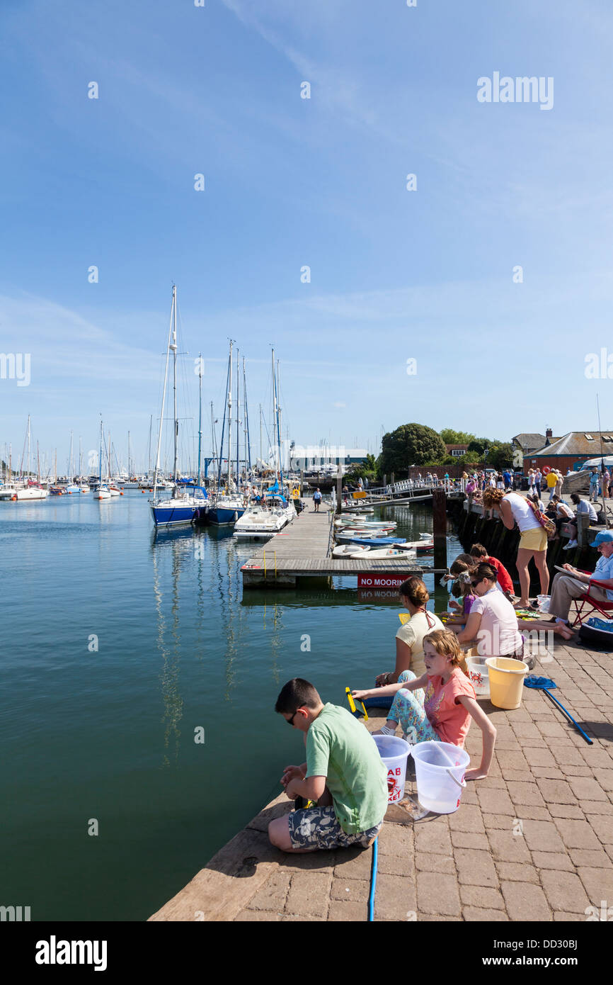 Children crab fishing on the Quay and harbour marina in Lymington