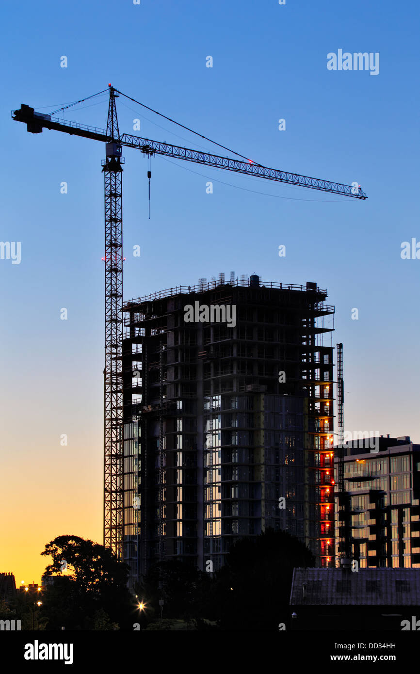 Construction crane on new condominium building at predawn-Victoria, British Columbia, Canada. Stock Photo