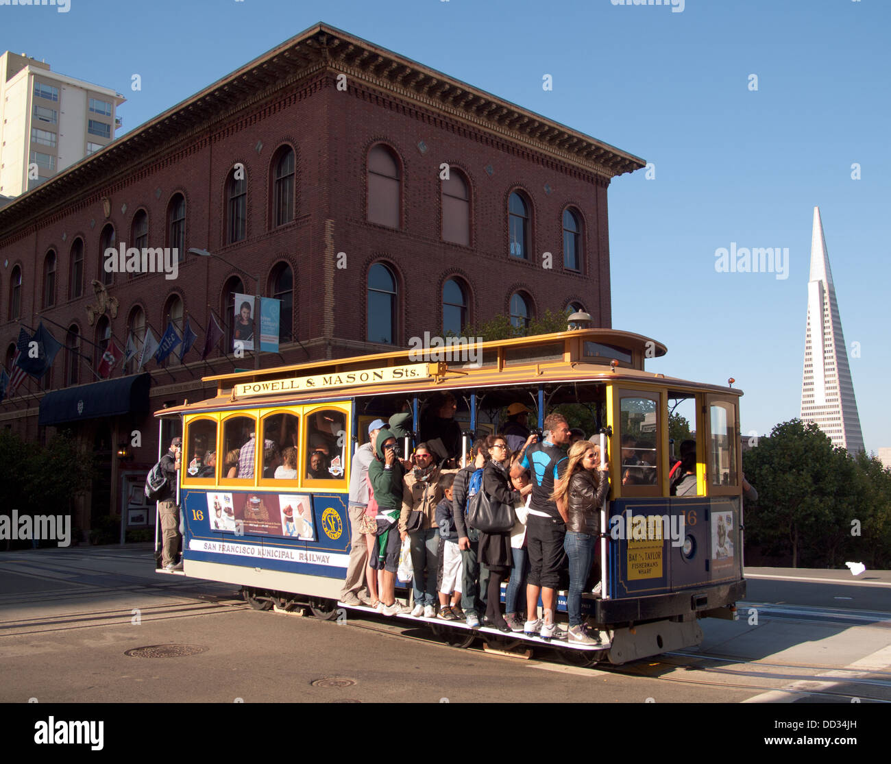 The Powell-Mason Cable Car on Nob Hill with the University Club of San Francisco and the Transamerica Pyramid in the background. Stock Photo