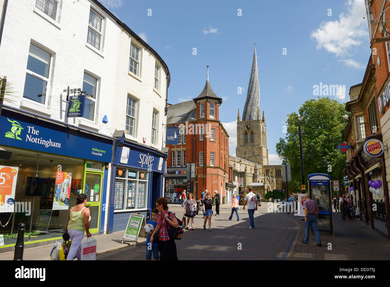 Shoppers walking through Chesterfield town centre near to St Mary's Church Stock Photo