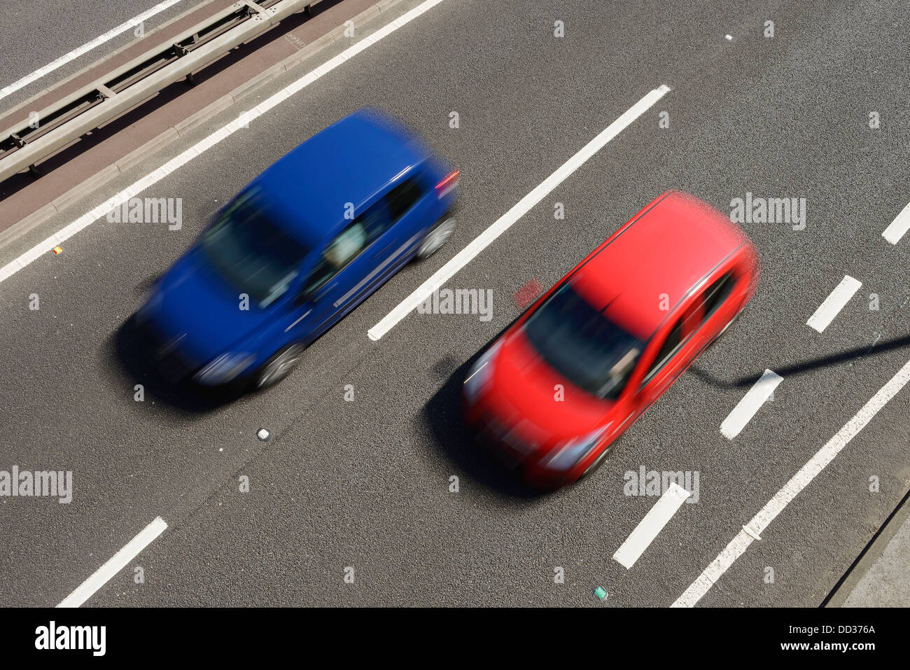 Overhead view of a red car and a blue car speeding on a road Stock Photo