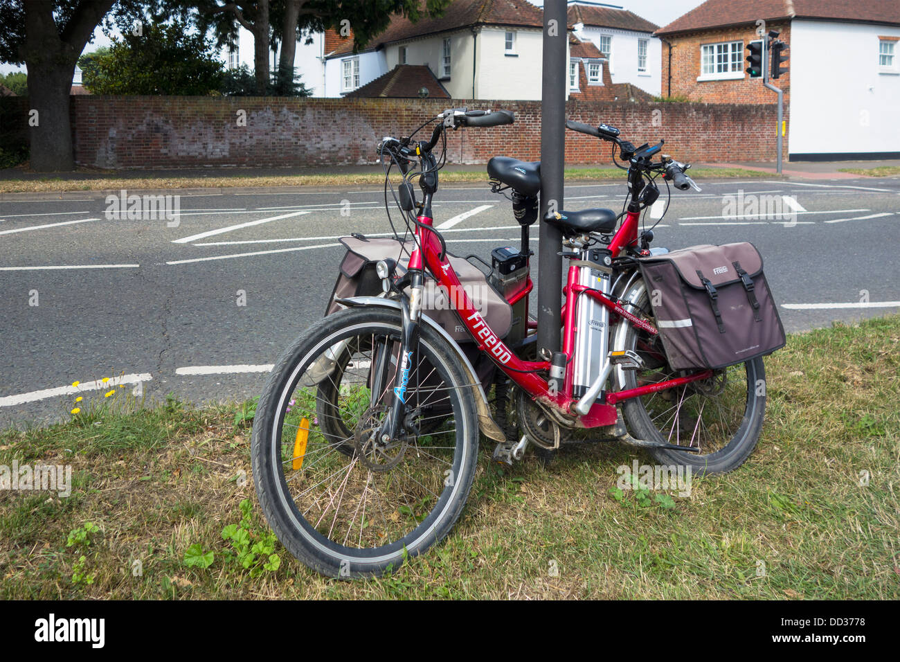 Two freeGo battery powered bicycles secured to a signpost which have