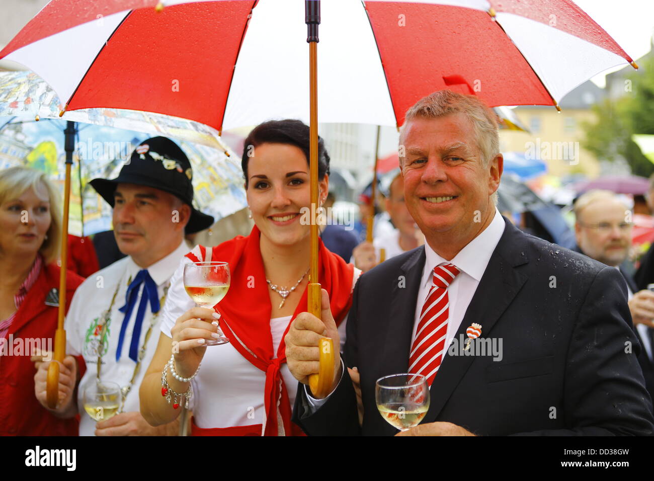 Worms, Germany. 25th August 2013. The Lord Mayor of Worms, Michael Kissel (R) and the Backfischbraut (bride of the mayor of the fishermenÕs lea), Jana Berger (L), are pictured with a glass of wine in their hands. The largest wine fair along the Rhine, the Backfischfest, started its 80th anniversary in  Worms with the traditional handing over of power from the Lord Mayor to the mayor of the fishermenÕs lea. The ceremony included dances and music. Credit:  Michael Debets/Alamy Live News Stock Photo