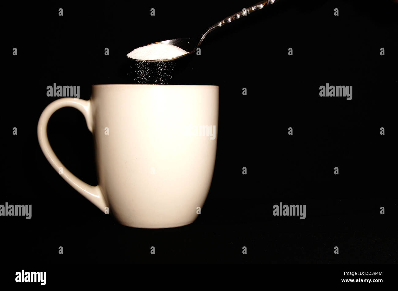 Pouring hot water into into a cup on a black background, Stock image