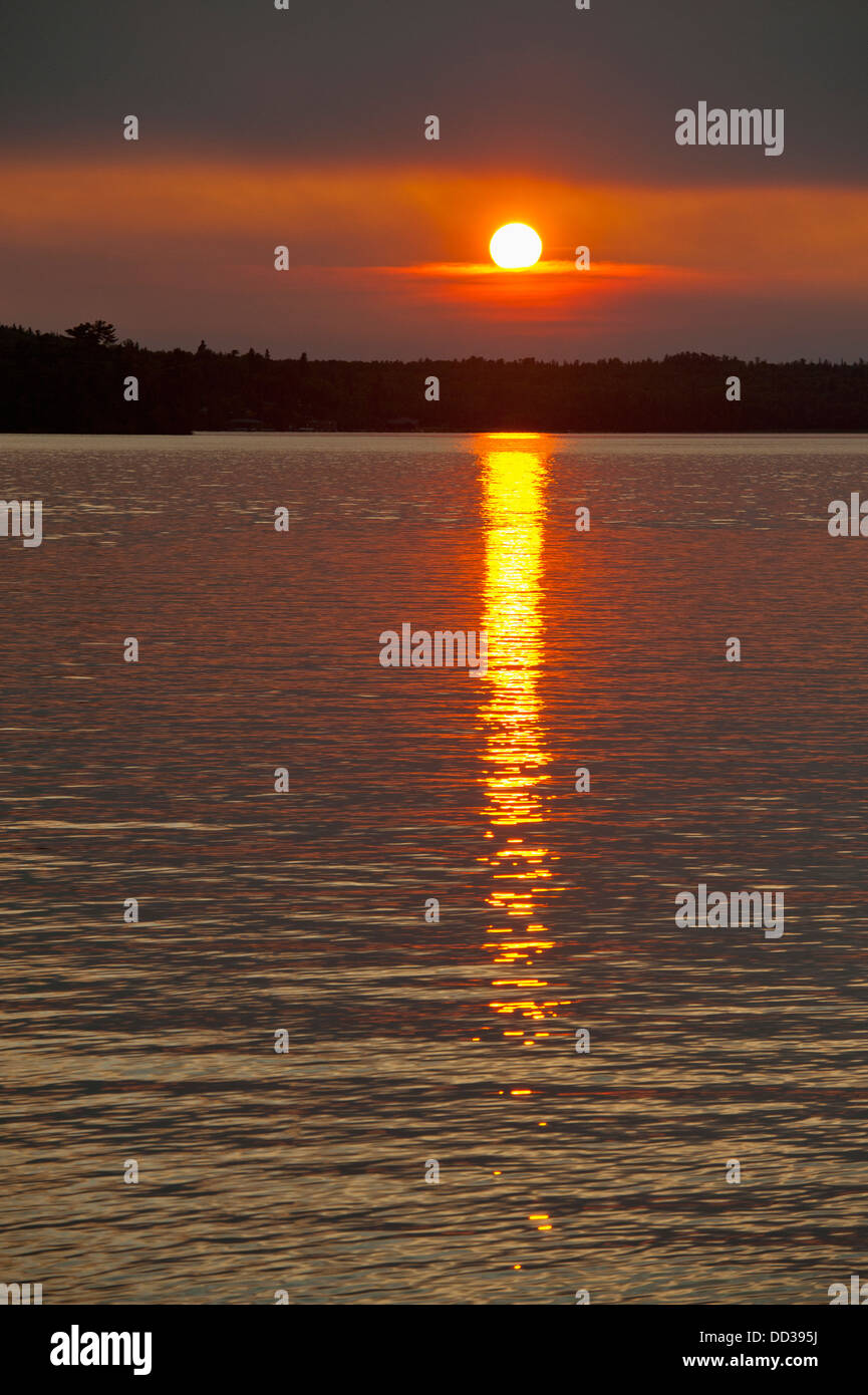 Sunlight Reflecting On A Tranquil Lake At Sunset; Lake Of The Woods ...
