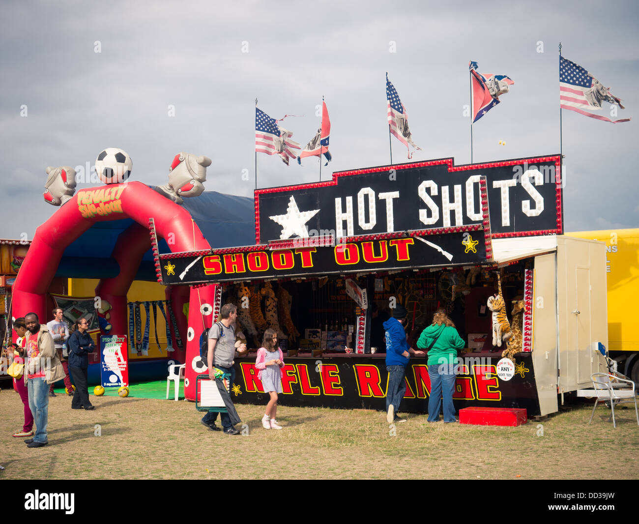 A shooting gallery at a traveling funfair with tattered American and confederate flags flying Stock Photo