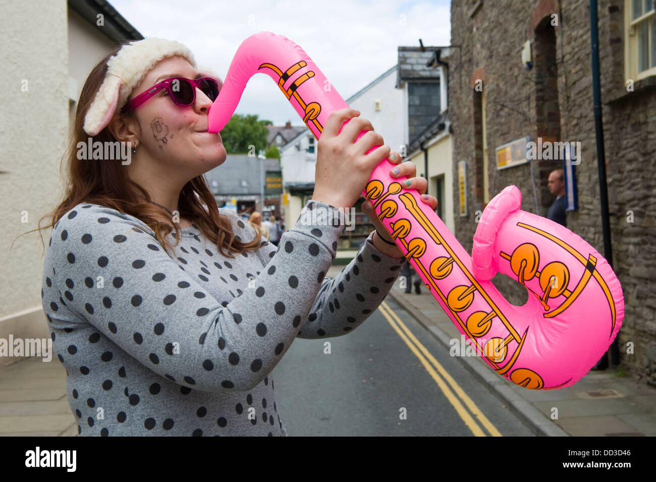 Young woman playing air sax on the street during Brecon Jazz Festival 2013 Stock Photo