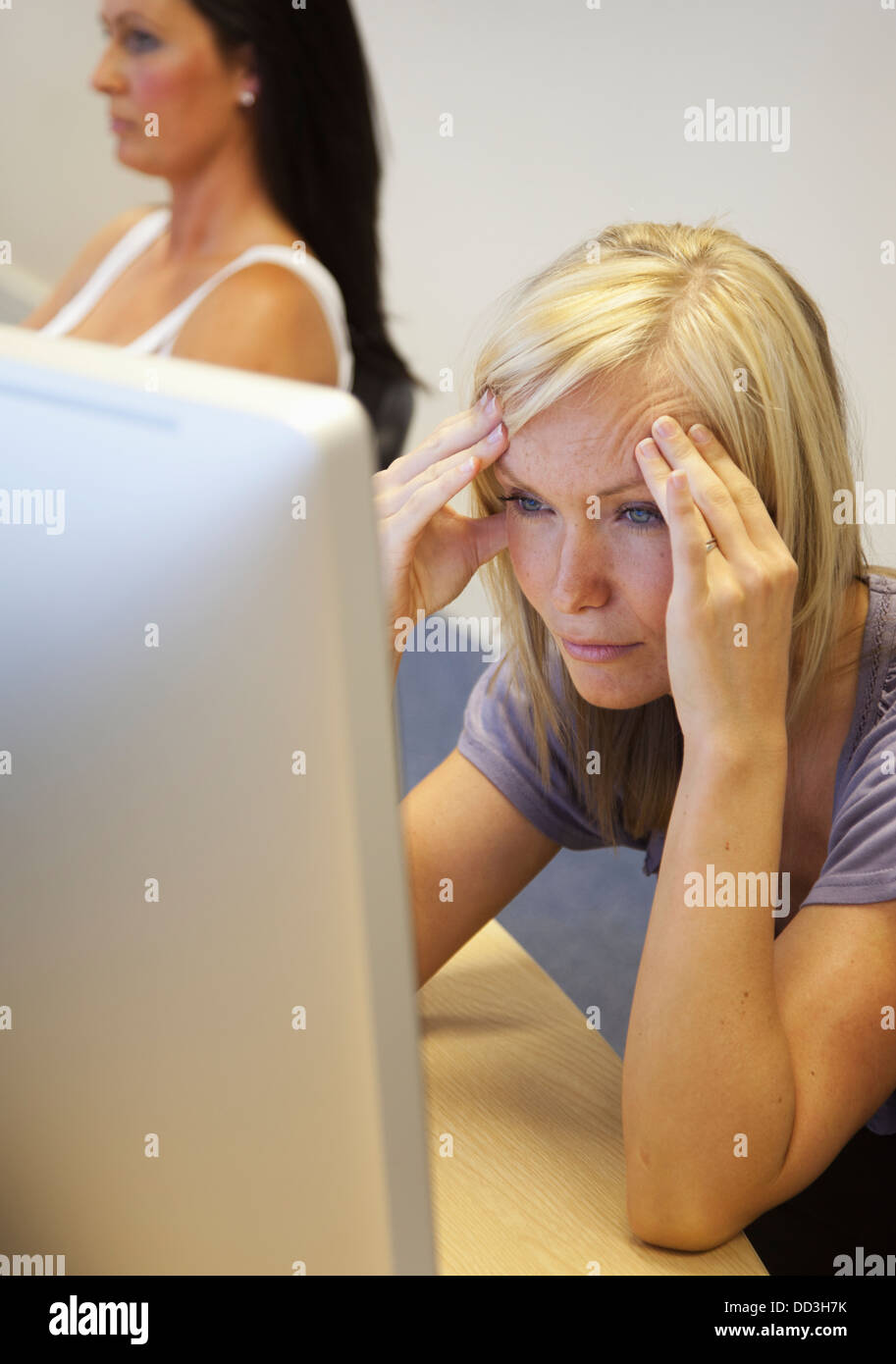 A Young Woman Struggles To Understand As She Reads From Her Computer Screen; South Shields, Tyne And Wear, England Stock Photo
