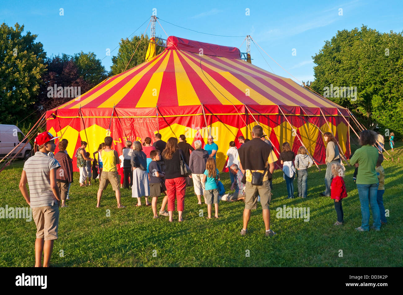 Striped yellow and red circus tent with crowd - France. Stock Photo