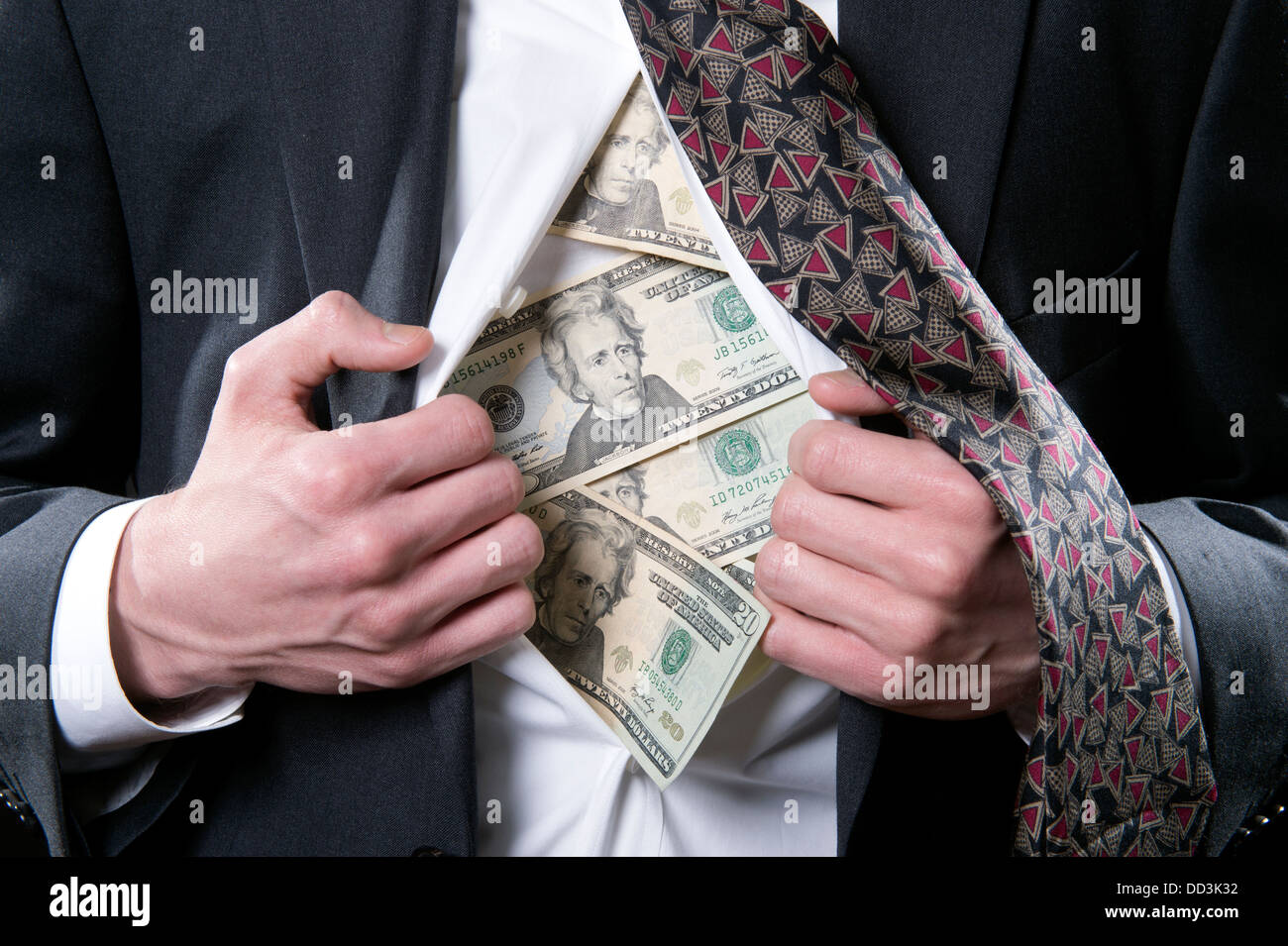 Concept photo for hidden money showing a businessman pulling back his shirt exposing twenty dollar bills Stock Photo
