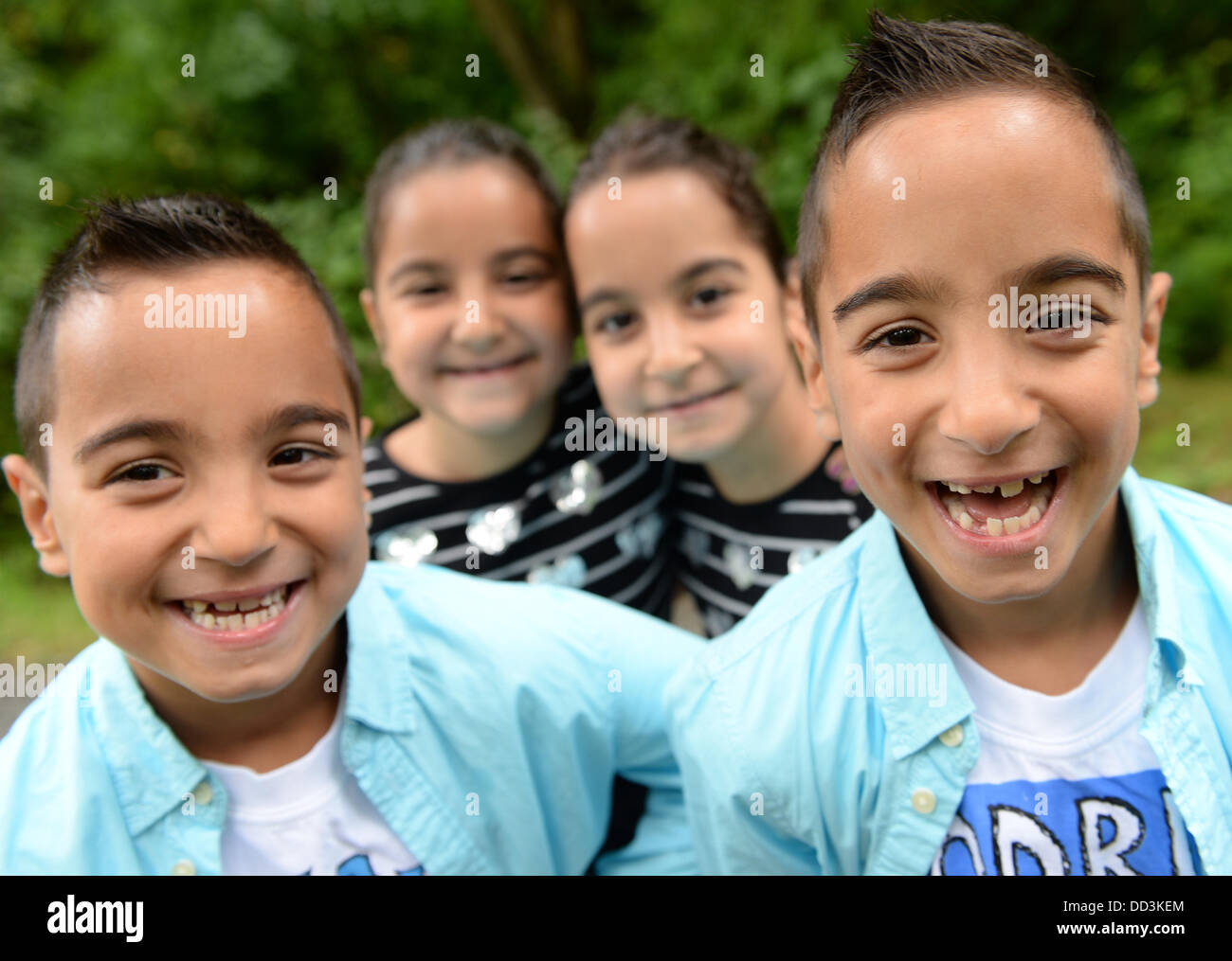 The quadruplets Ahmed (L-R, 6), Reyyan, Dilay and Mustafa look into the camera at the Triplet meeting held at Hessen Park on a rainy day in Neu-Anspach, Germany, 25 August 2013. The governor of Hesse is a godfather for all children of multiple births and hosts an event each year for them. Photo: ARNE DEDERT Stock Photo