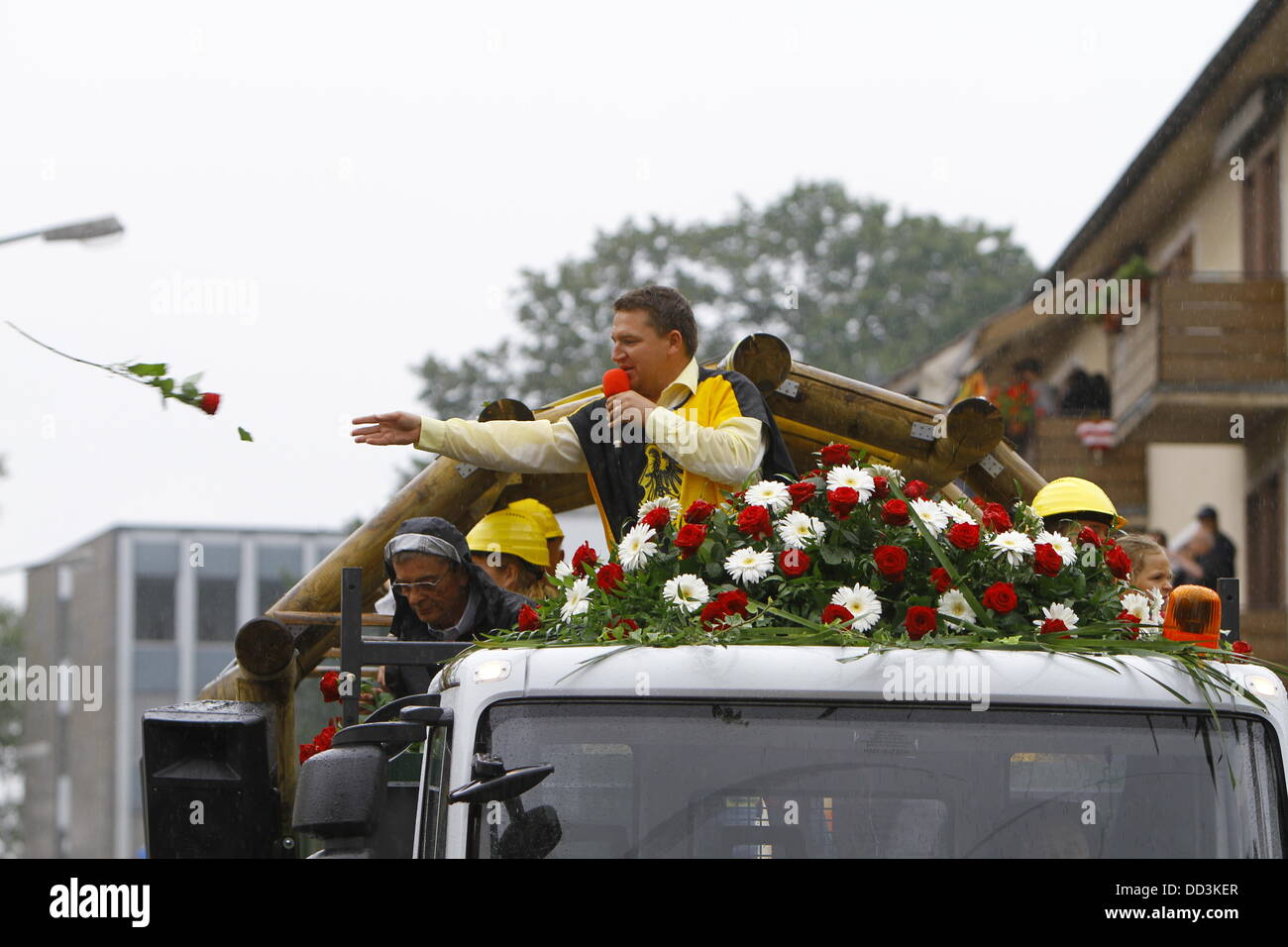 Worms, Germany. 25th August 2013. A participant of the Backfischfest parade 2013 throws roses into the crowd. The first highlight of this year's Backfischfest was the big parade through the city of Worms with over 100 groups and floats. Community groups, sport clubs, music groups and business from Worms and further afield took part. Credit:  Michael Debets/Alamy Live News Stock Photo