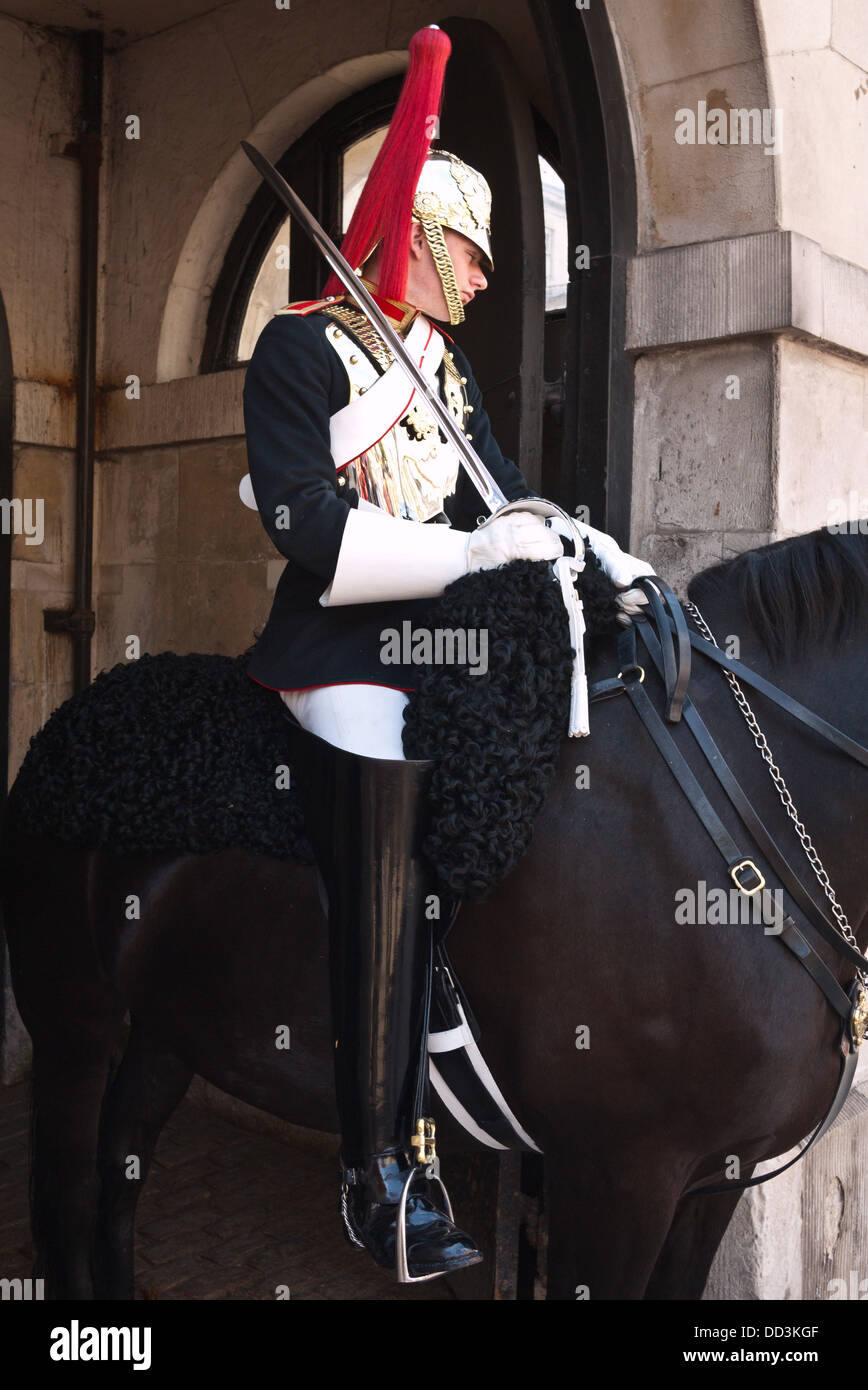 A  Queen's Life Guard', mounted on an immaculately groomed horse on duty at the entrance arch to Horseguards Parade Ground the official entrance to St James and Buckingham Palace Stock Photo
