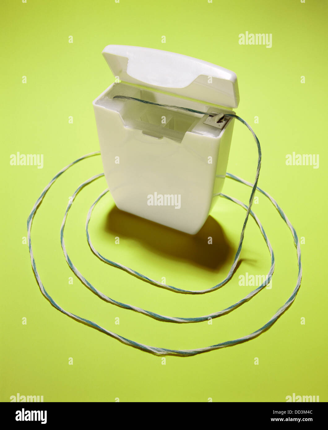 Dental floss string around a white container. Stock Photo