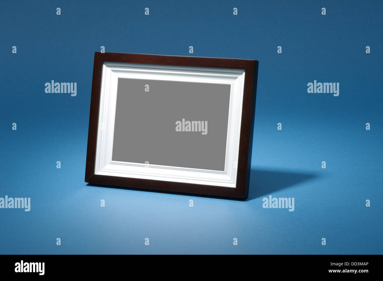 A small tabletop picture photo frame on a blue background with dramatic
