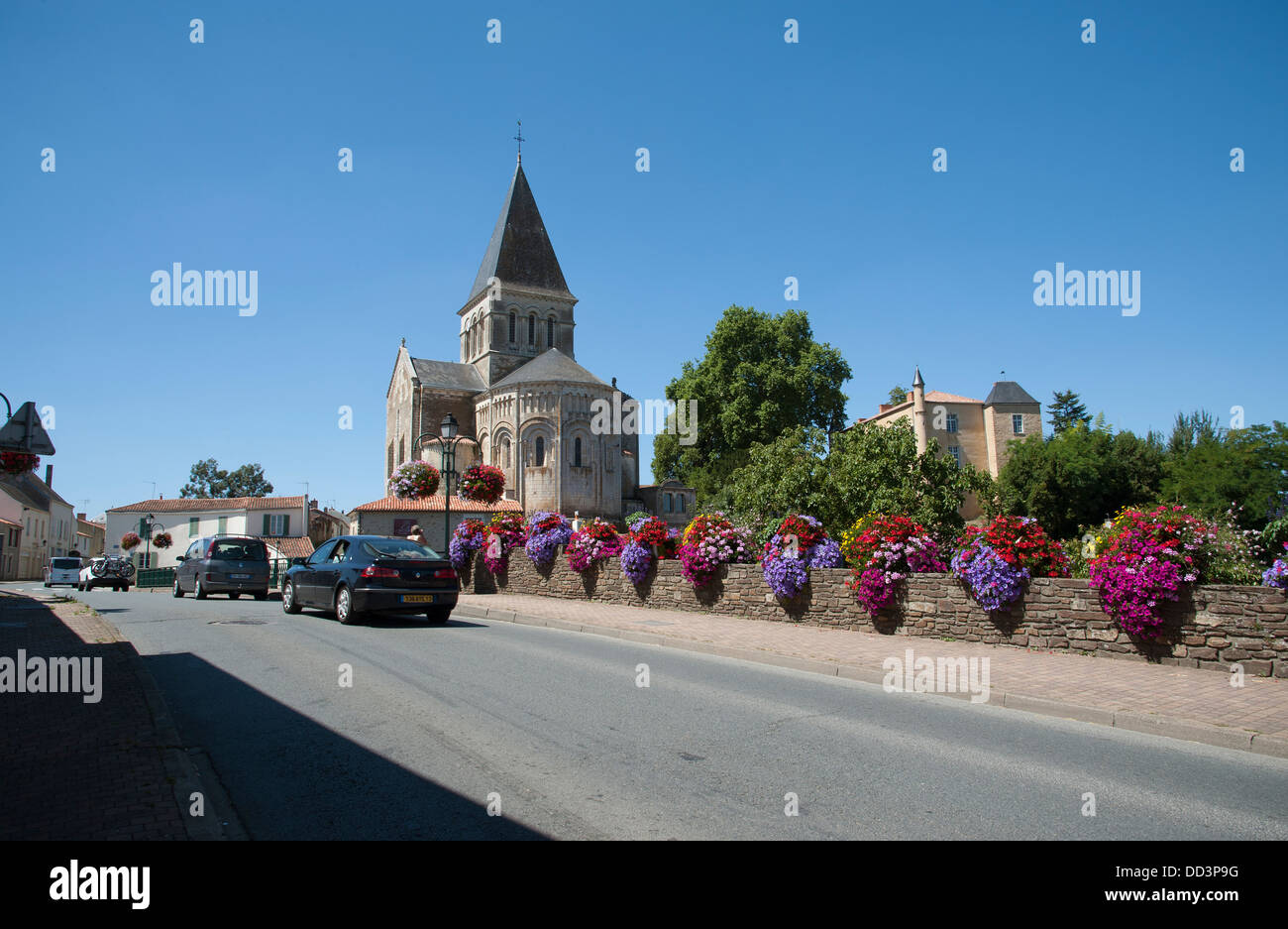 Flowers decorating the roadside at Mareuil sur Lay in the Vendee region of France and the Romanesque church of St Sauveur VII c Stock Photo