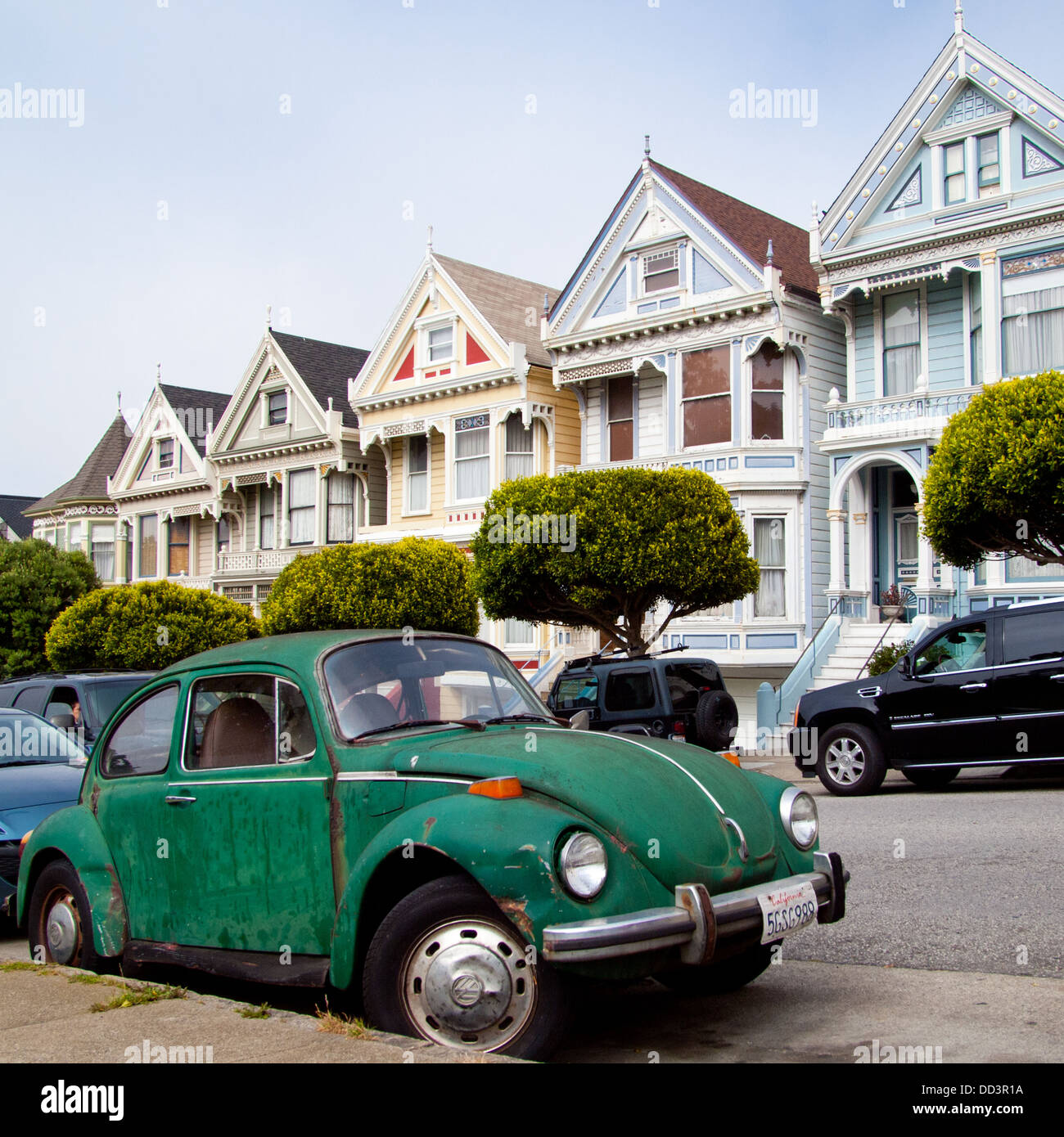 A vintage Volkswagen Beetle, parked in front of the famous 'Painted Ladies' of Steiner Street at Alamo Square in San Francisco. Stock Photo