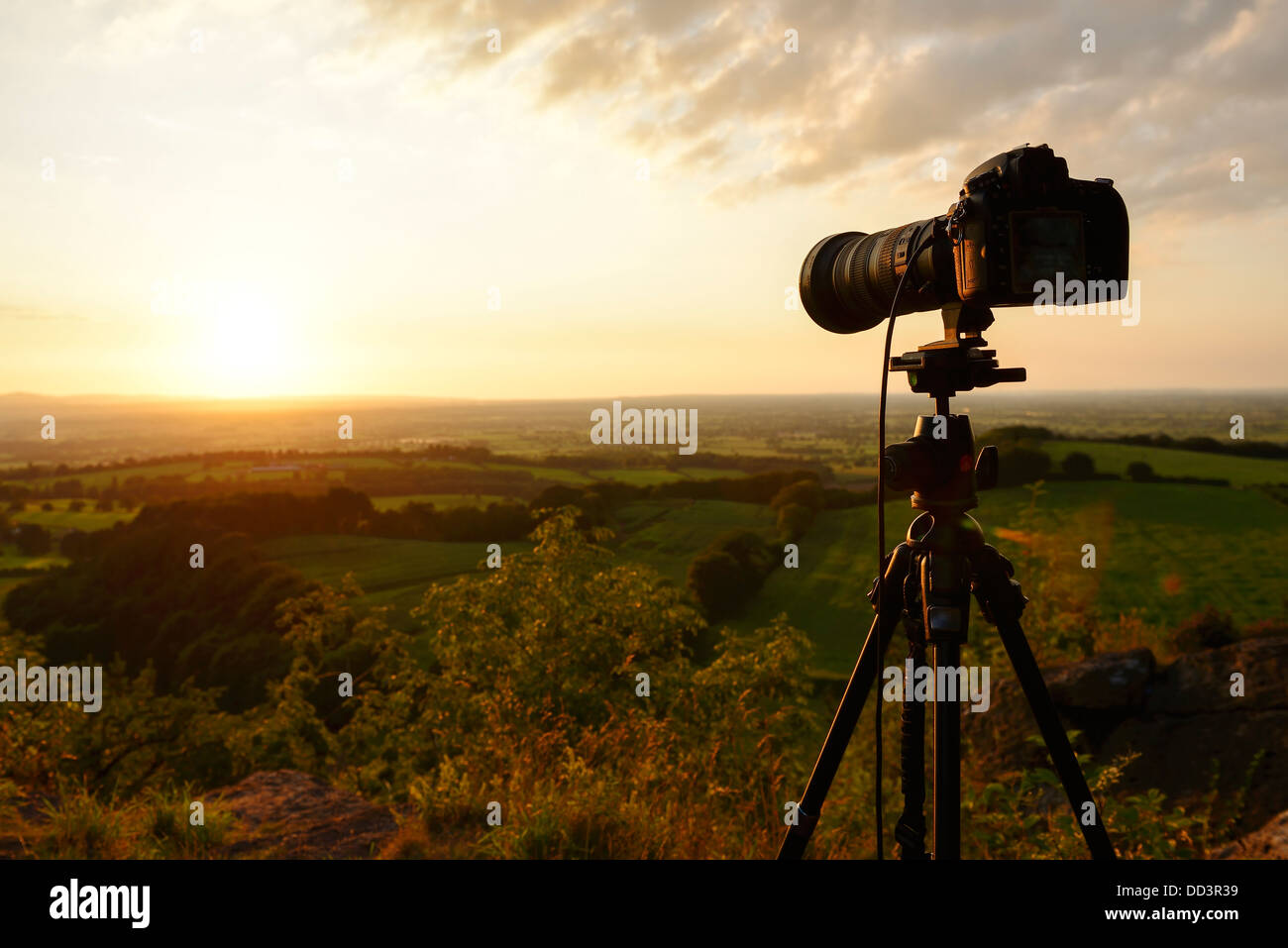 Nikon D800 camera and tripod taking a sunset landscape photograph looking over the Cheshire Plain UK Stock Photo