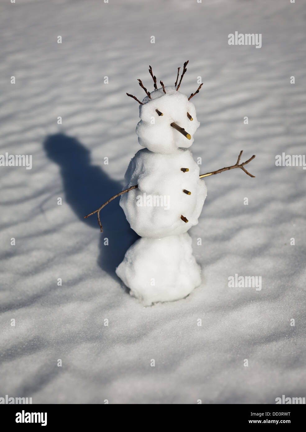 Small funny snowman on the background of the snow-drift Stock Photo
