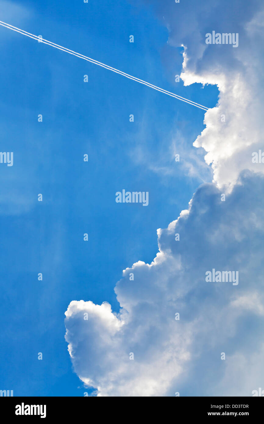 cloudscape with trace of air plane in blue sky in summer evening Stock Photo